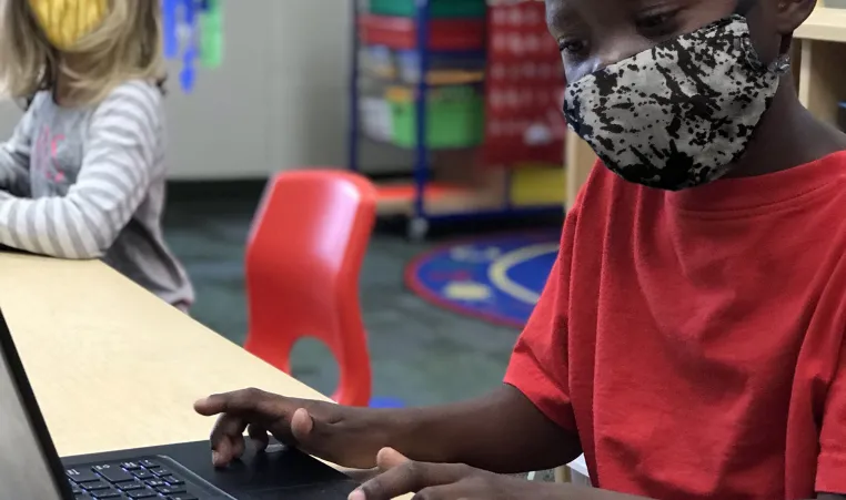 Child working on a computer during school