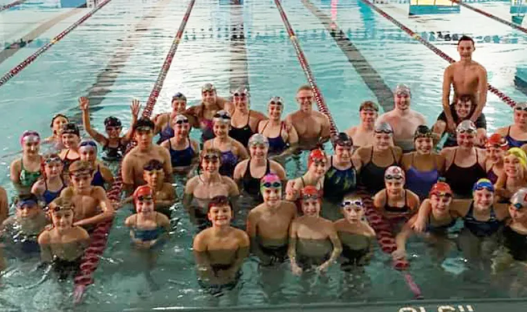 DCY swimmers posing in the pool during their midnight swim