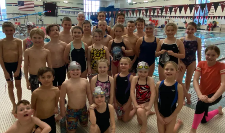 Participants of the DCY swim team pose on the pool deck at the sectional meet